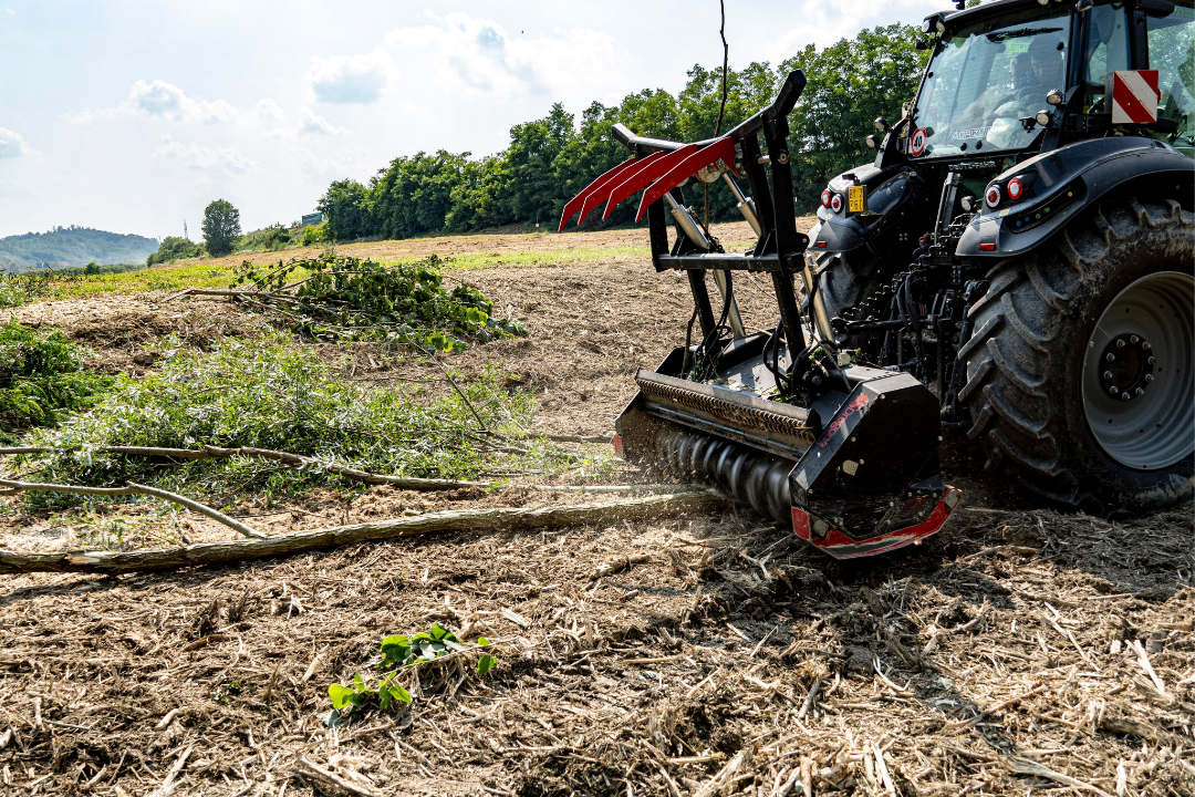 Mesin penghancur kayu Dragone ditarik oleh traktor di area hutan